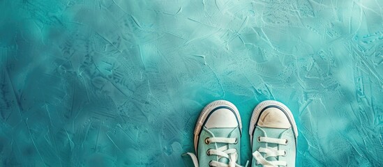 Poster - Aquamarine background with adorable toddler shoes copy space image