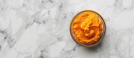 Poster - Top view of a delicious sweet potato puree in a bowl on a marble surface with a blank space available for additional images