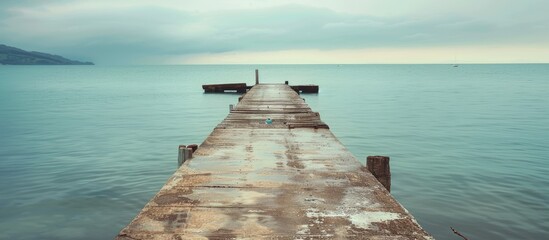 Fototapete - Concrete pier offers picturesque view of tranquil sea with copy space image