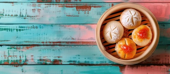 Aufkleber - A bamboo bowl filled with steamed bread topped with coconut jam is placed on a colorful wooden table providing a perfect copy space image from above