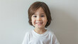 © VK Studio - A young boy with a broad smile stands against a neutral background, showcasing his cheerful and innocent nature.