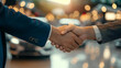 © Maksym - Detailed view of a handshake symbolizing a closed car deal, with a brand-new vehicle in the background