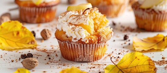 Poster - A broken homemade Apple cupcake with Apple filling on a light background with yellow leaves evokes the essence of fall baking and harvest in the copy space image