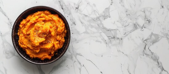 Poster - Top view of a delicious sweet potato puree in a bowl on a marble surface with a blank space available for additional images