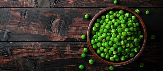 Sticker - A bowl of fresh green peas on a dark wooden backdrop from above with room for text or images. Creative banner. Copyspace image