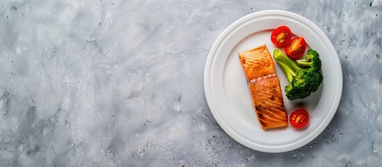 Sticker - Diet food concept with a grilled salmon steak broccoli and tomatoes on a white plate against a gray copy space image