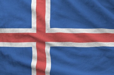 Iceland flag depicted on folded wavy fabric of old cloth close up