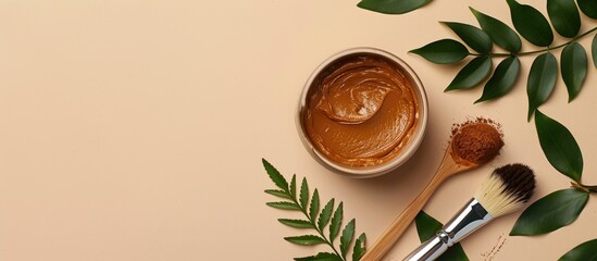 Poster - Flat lay with a bowl of henna cream a brush green leaves and copy space image on a beige background for natural hair coloring perfect for text placement