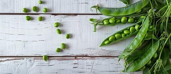 Poster - Top down view of fresh green pea pods on a white wooden table with space for text or image insertion. Creative banner. Copyspace image