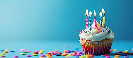 Wall Mural - Color background enhances the birthday cupcake with candles in the copy space image