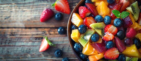 Aufkleber - Close up of a delicious fruit salad in a bowl on a wooden table with copy space image