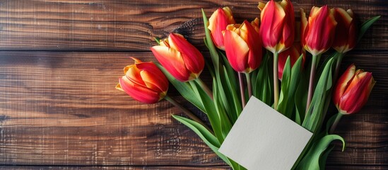 Aufkleber - A bouquet of tulips displayed with an empty paper card on a wooden background with copy space image