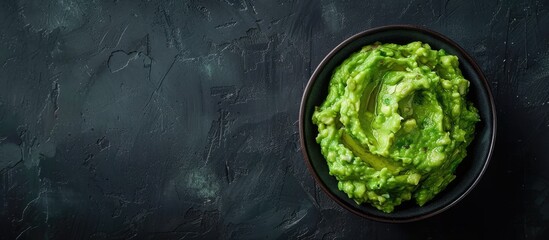 Aufkleber - Avocado guacamole in a grey bowl set against a dark backdrop featuring a top view for a copy space image