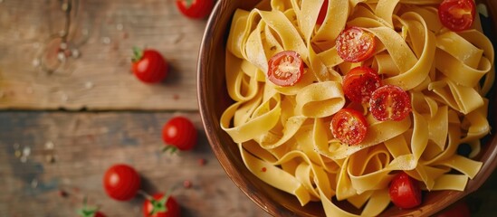 Aufkleber - Bowl with raw pasta and cherry tomatoes displaying an appealing copy space image
