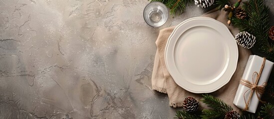 Poster - Top view of Christmas table with a white plate glass presents and pine branch on a stone surface perfect for showcasing in images with space for text. Creative banner. Copyspace image