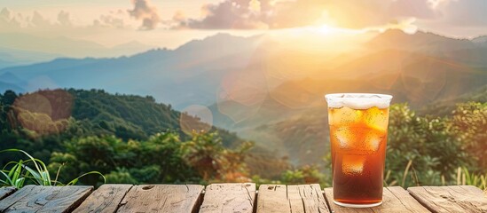 Poster - Cold drink on wooden table with mountain backdrop in copy space image