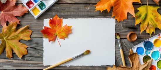 Aufkleber - Autumn themed artist s workspace with a sheet of paper watercolor paint set brush and autumn leaves arranged for a top view copy space image