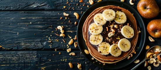 Poster - Delicious thin pancakes with chocolate paste sliced banana and nuts on a black wooden background set against a blank space for text or images. Creative banner. Copyspace image