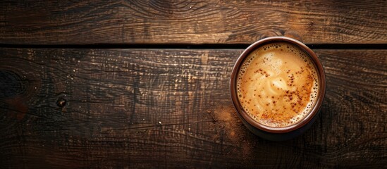 Aufkleber - Top view of a cappuccino topped with milk on a dark wooden surface showcasing a free copy space image