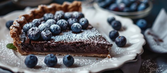 Sticker - Close up horizontal image of chocolate pie in a white plate garnished with blueberries and powdered sugar featuring copy space image