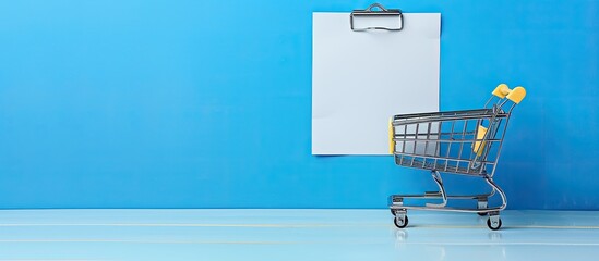 Aufkleber - Blue background with a shopping cart and text highlighting key points on a white paper note list creating a shopping list concept with copy space image