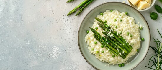 Aufkleber - Top down view of Italian risotto with fresh spring asparagus and parmesan cheese served on a plate against a bright background providing space for additional elements in the image
