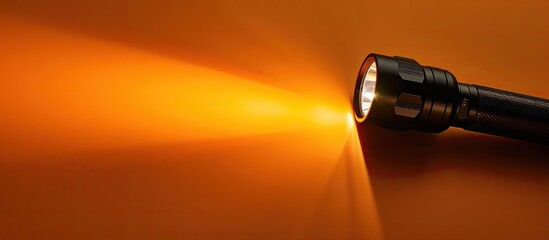 Canvas Print - A black flashlight on an orange background with light shining on the way leaving room for text or images. Creative banner. Copyspace image