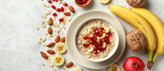 Aufkleber - Flat lay composition of a nutritious breakfast featuring oatmeal topped with nuts pomegranate seeds and bananas on a white surface with room for text or other images copy space image