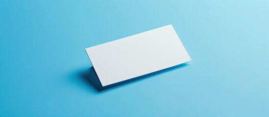 Fototapete - A blank name card is elegantly placed on a blue background with an empty space for text or images ideal for showcasing in a copy space image