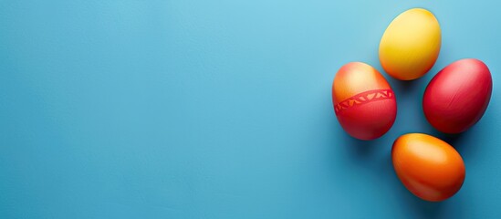 Aufkleber - A blue background features three vibrant Easter eggs in red yellow and orange hues providing ample copy space for text within the image