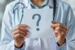 © PRASANNAPIX - young doctor holding white paper with question mark