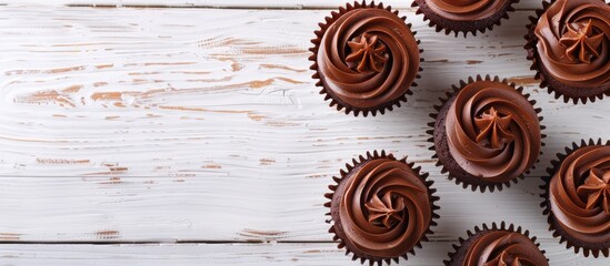 Poster - Top view of chocolate cupcakes on a white wooden table providing copy space in the image