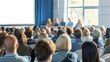 © CK Studio - Large audience gathered for a professional seminar, paying attention to the panelists on stage.