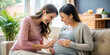 © Anhen Design - Two women sharing a joyful moment as one woman feels the pregnant belly of the other, capturing the excitement and anticipation of pregnancy