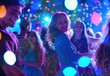 © KumCup - People dancing at a colorful and lively party with bright lights and smiles.