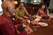 © DragonImages - Indian friends having dinner together during their meeting at home