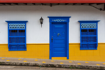 Wall Mural - Beautiful traditional colonial facade in the historical village of Jardin, Jardín, Antioquia, Colombia. Colorful wooden carved doors and windows.