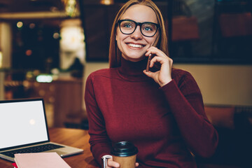 Canvas Print - Happy woman talking with friend via mobile app in break from e learning on laptop computer with mock up blank for advertising text, cheerful hipster girl making positive telephone conversation