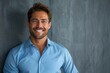 © mattegg - Confident Smiling Businessman in Blue Shirt Against Gray Background