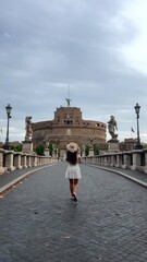 rome, a girl walks across the bridge to the angel's castle