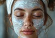 © YONG - A young woman with closed eyes wearing a white face mask for skin care and beauty treatment,Beauty concept