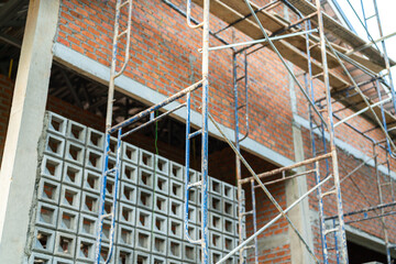 Close-up at metal scaffolding structure at the housing construction building site. Industrial working equipment object photo, selective focus.