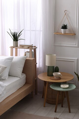 Poster - Stylish living room interior with bed, bedside tables, lamp and houseplants
