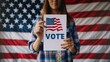 © Marco - woman holding a sign that says vote with the usa flag and the usa flag in the background