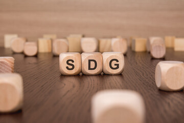 Sticker - SDG text 'Sustainable Development Goals' wooden cube blocks on table background