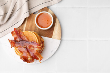 Wall Mural - Delicious pancakes with bacon and honey on white tiled table, top view. Space for text