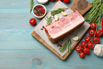 Wall Mural - Piece of raw bacon with spices and tomatoes on light blue wooden table, flat lay. Space for text