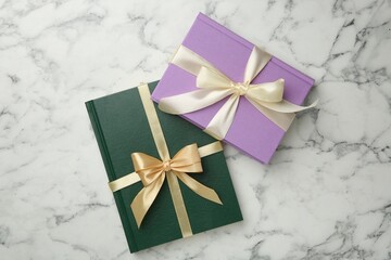 Wall Mural - Books tied with ribbons on white marble table, top view