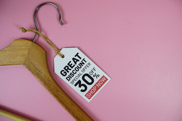 Wall Mural - Great Discount sale up to 30% off on price tag with wooden clothes hanger top view on pink background