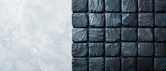 Canvas Print -  A monochrome image of a wall constructed from tiny black and white stones against a pristine white backdrop